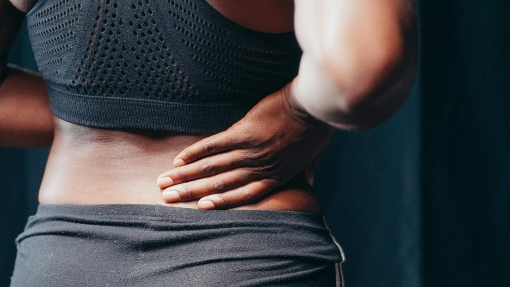 Persona con dolor lumbar sosteniendo la zona baja de la espalda.